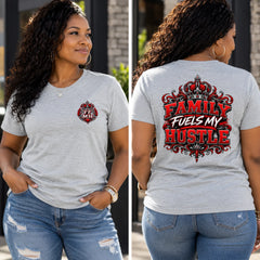 A woman shown in a split front-and-back view wearing a light heather gray graphic T-shirt and blue jeans. The front has a small red-and-black crest-style chest graphic, and the back has a large decorative red and black text graphic reading “FAMILY FUELS MY HUSTLE.