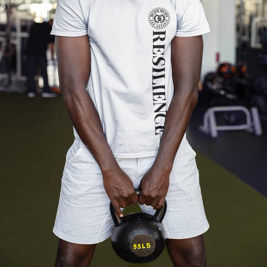 Model wearing Black Heart Tees Resilience Anchor t-shirt while training with a kettlebell at the gym