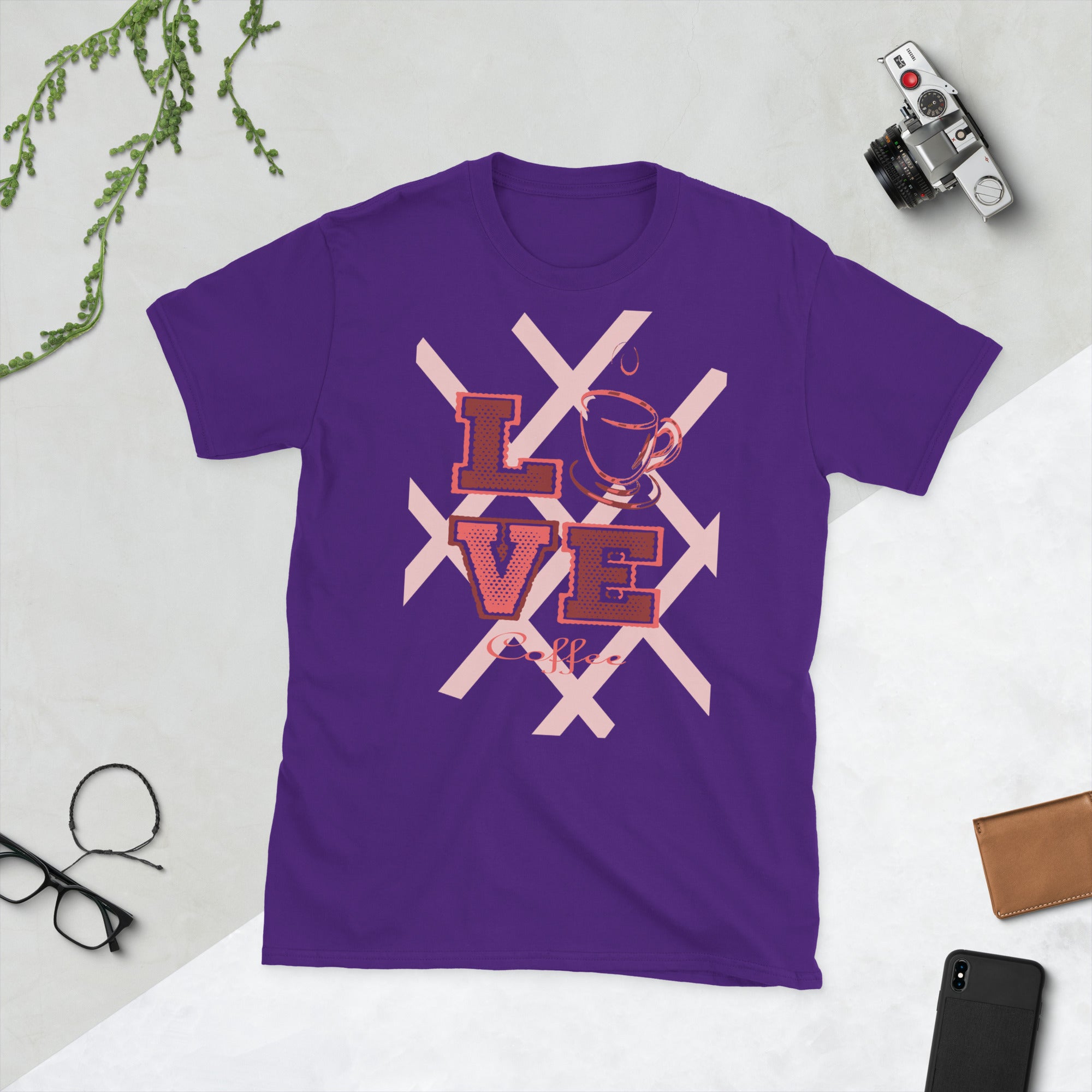 Purple t-shirt with 'LOVE' graphic on a light gray surface with accessories.