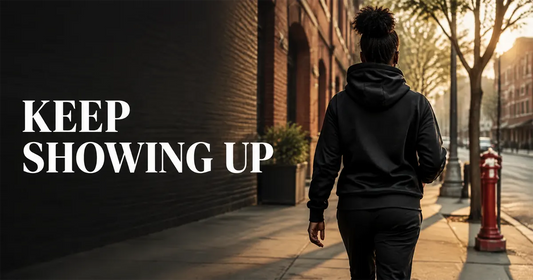 Woman in a black hoodie walking forward with the words Keep Showing Up