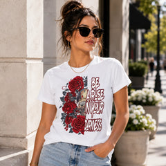 Woman wearing Be A Rose In Your Darkness white graphic tee with skull and red roses design in a bright urban setting – Black Heart Tees motivational apparel